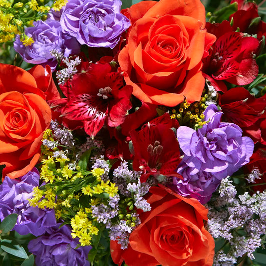 Vibrant Floral Arrangement with Orange Roses and Red Blooms